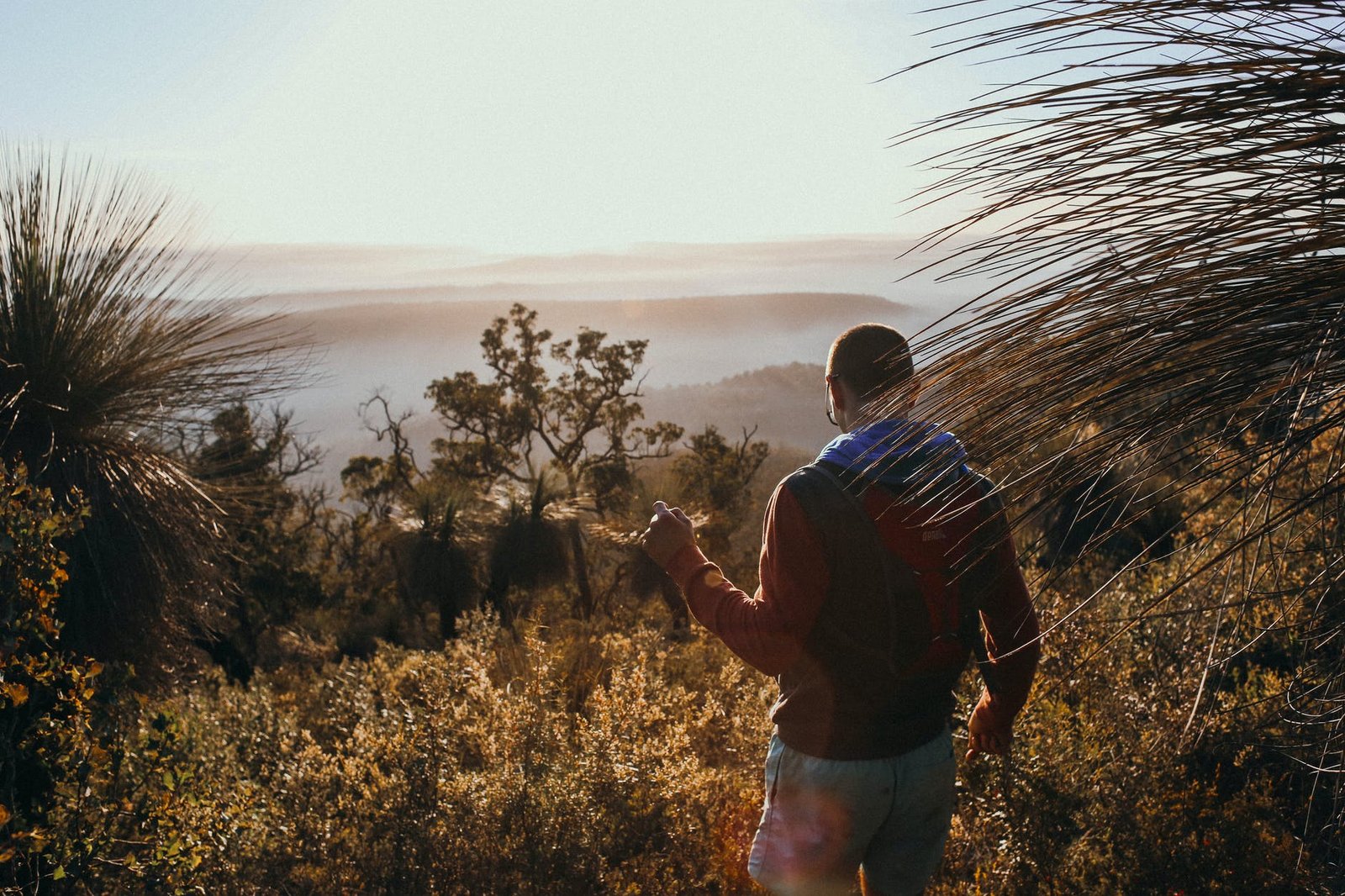 anonymous traveler standing above misty mountains