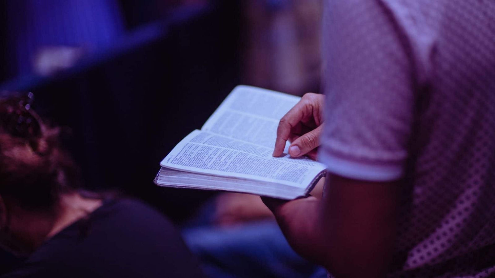 selective focus photo of person holding book. Let it go to God.