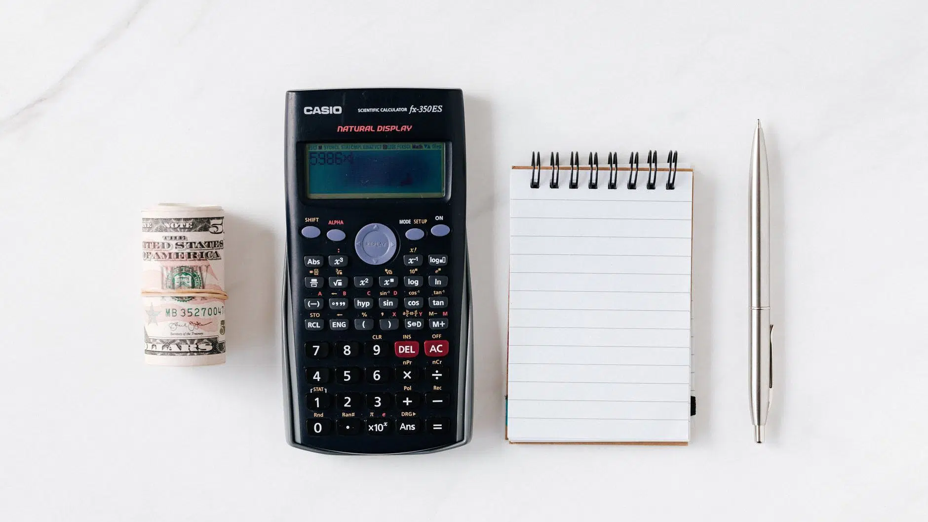composition of calculator with paper money and notebook with pen. Budget for finances!