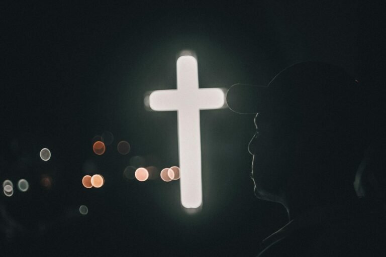 man by illuminated cross