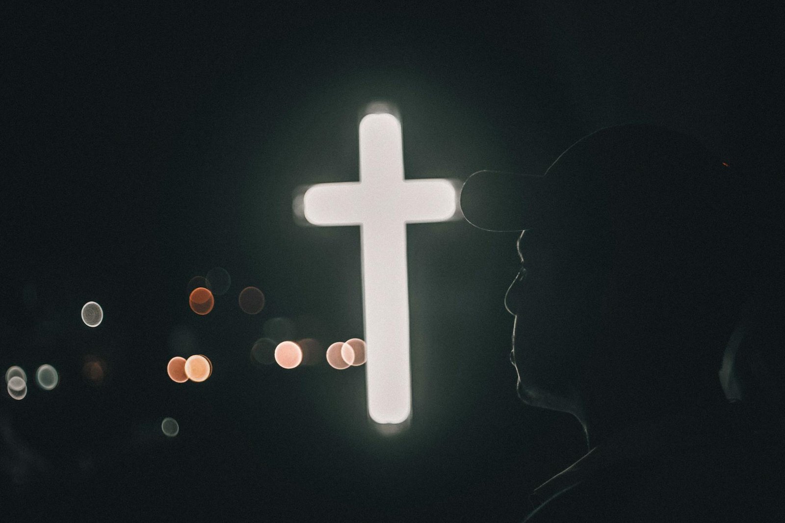 man by illuminated cross