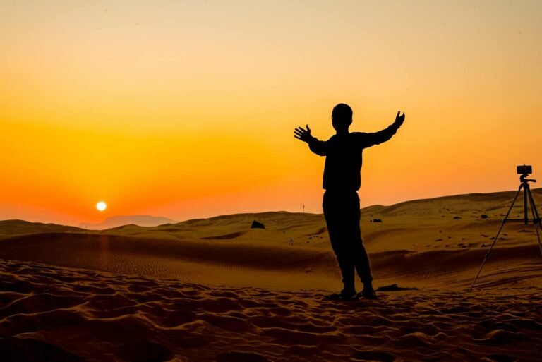 silhouette of man with photo camera in desert