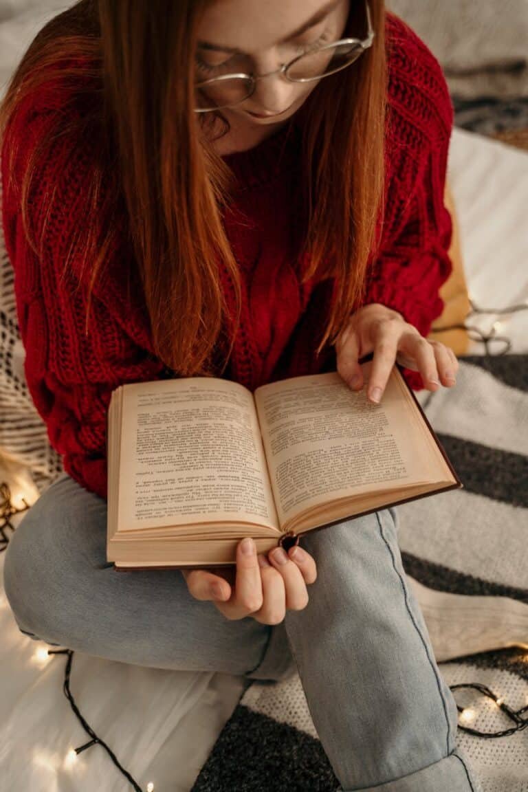 woman in red sweater reading book