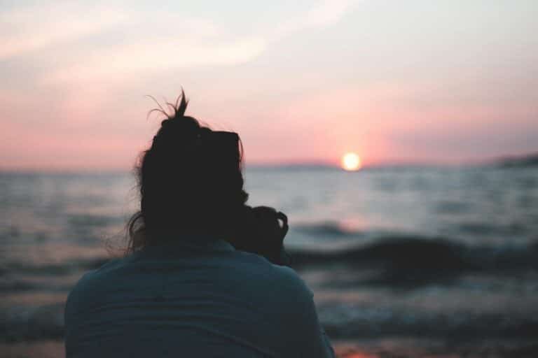 woman in white shirt standing near sea during sunset