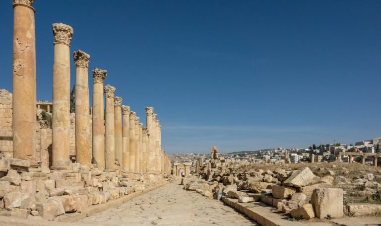 a brown concrete ruined structure near a city under blue sky