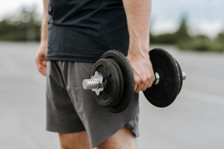 man carrying massive metal dumbbell in hand