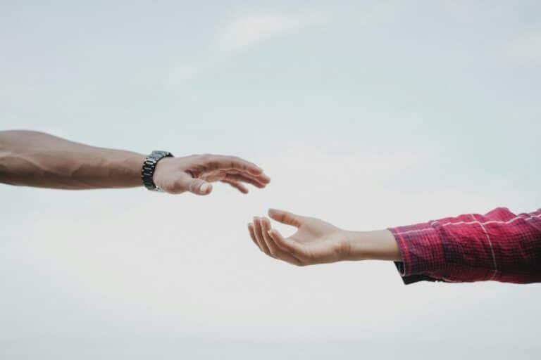 woman and man hands reaching each other