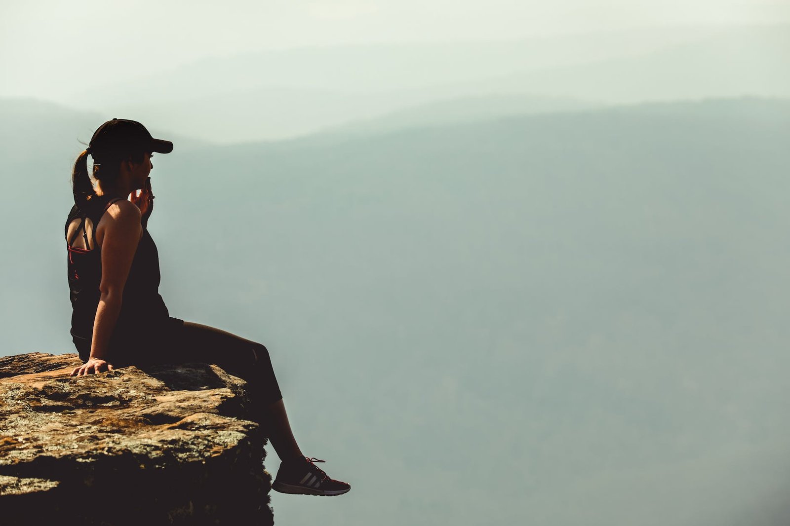 woman sitting on cliff