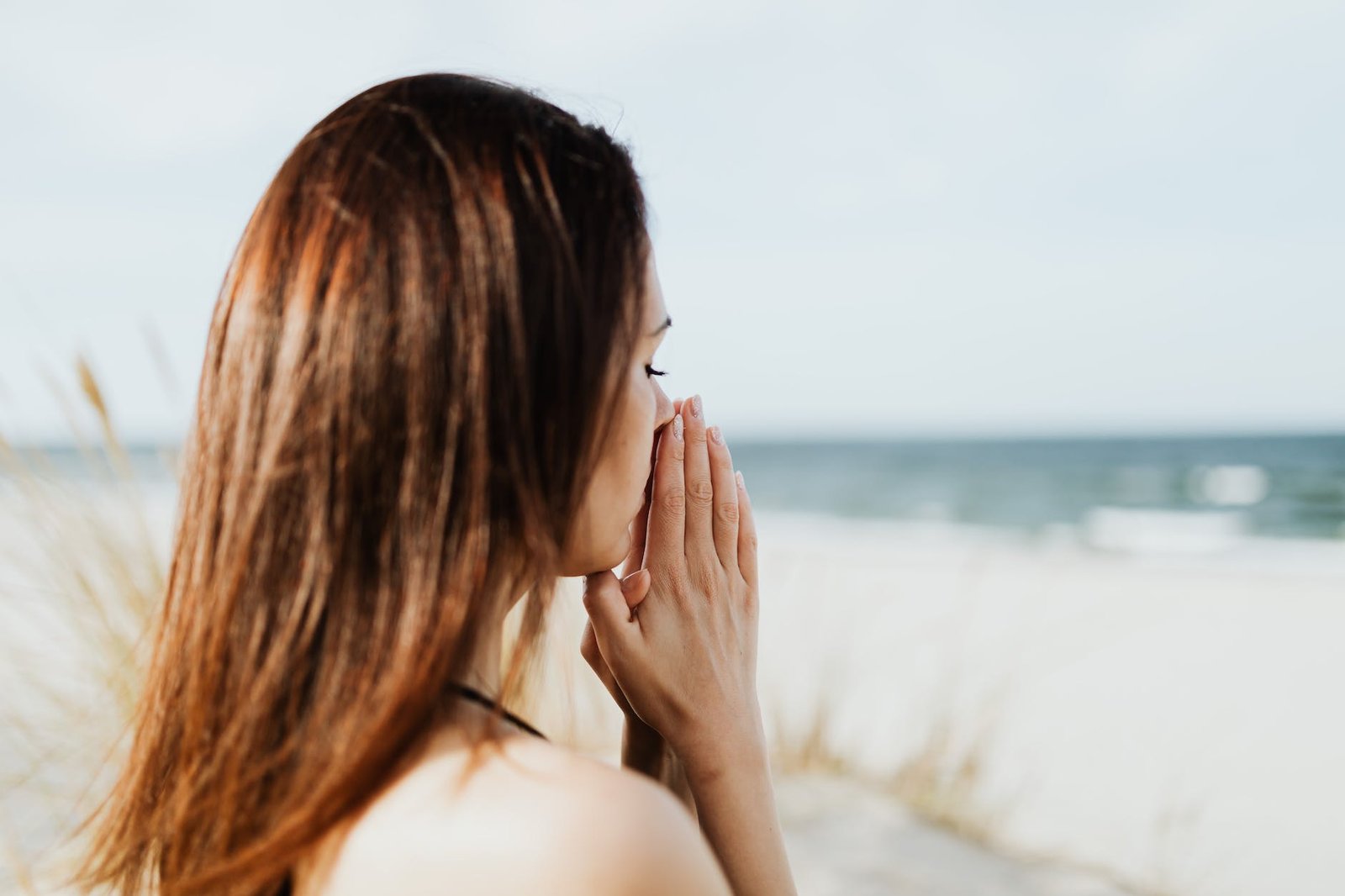 woman at the beach with her hands together