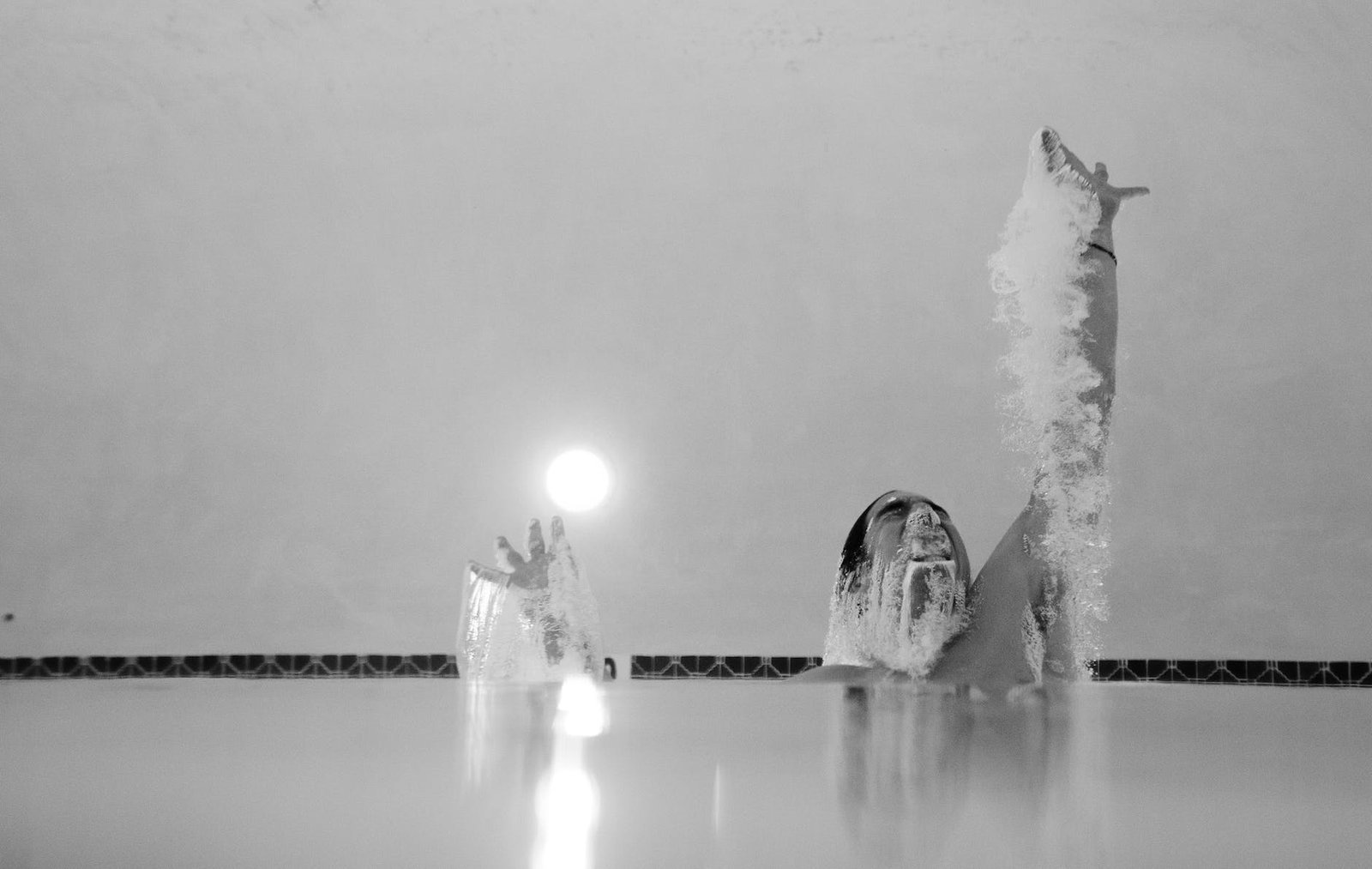 grayscale photo of person in swimming pool