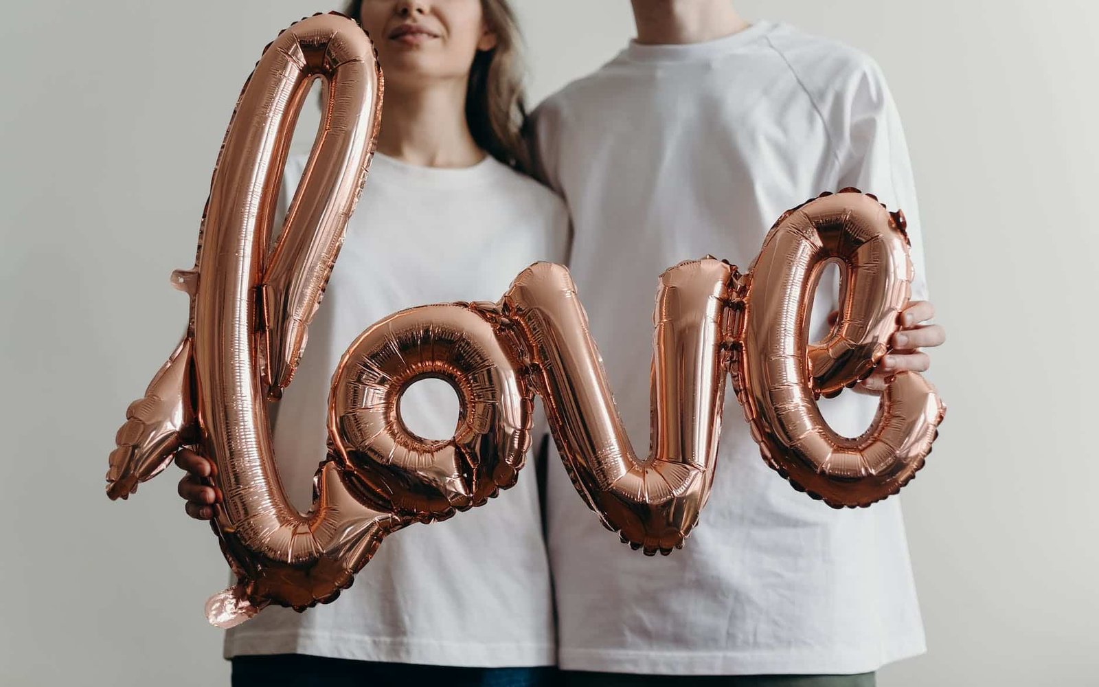 woman in white crew neck shirt with brown and white heart shaped beaded necklace