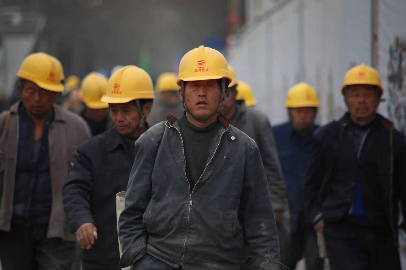 group of persons wearing yellow safety helmet during daytime