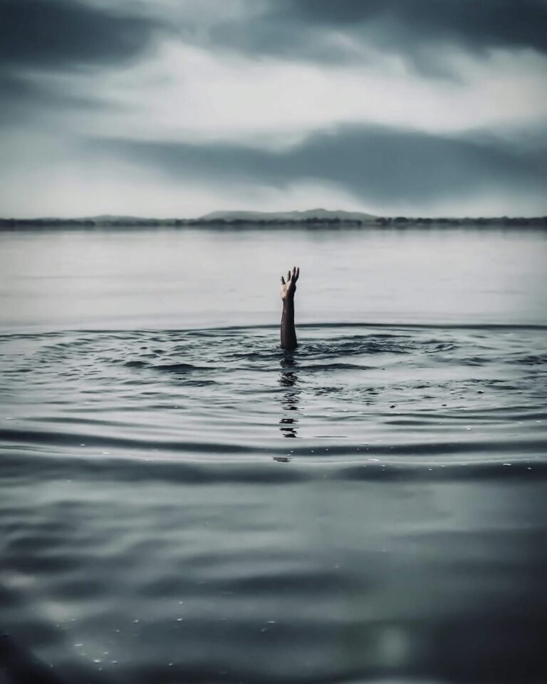 hand reaching out of a person drowning in water