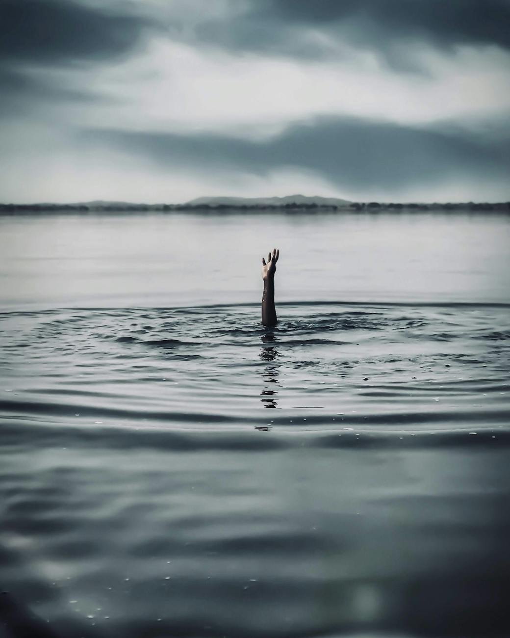 hand reaching out of a person drowning in water