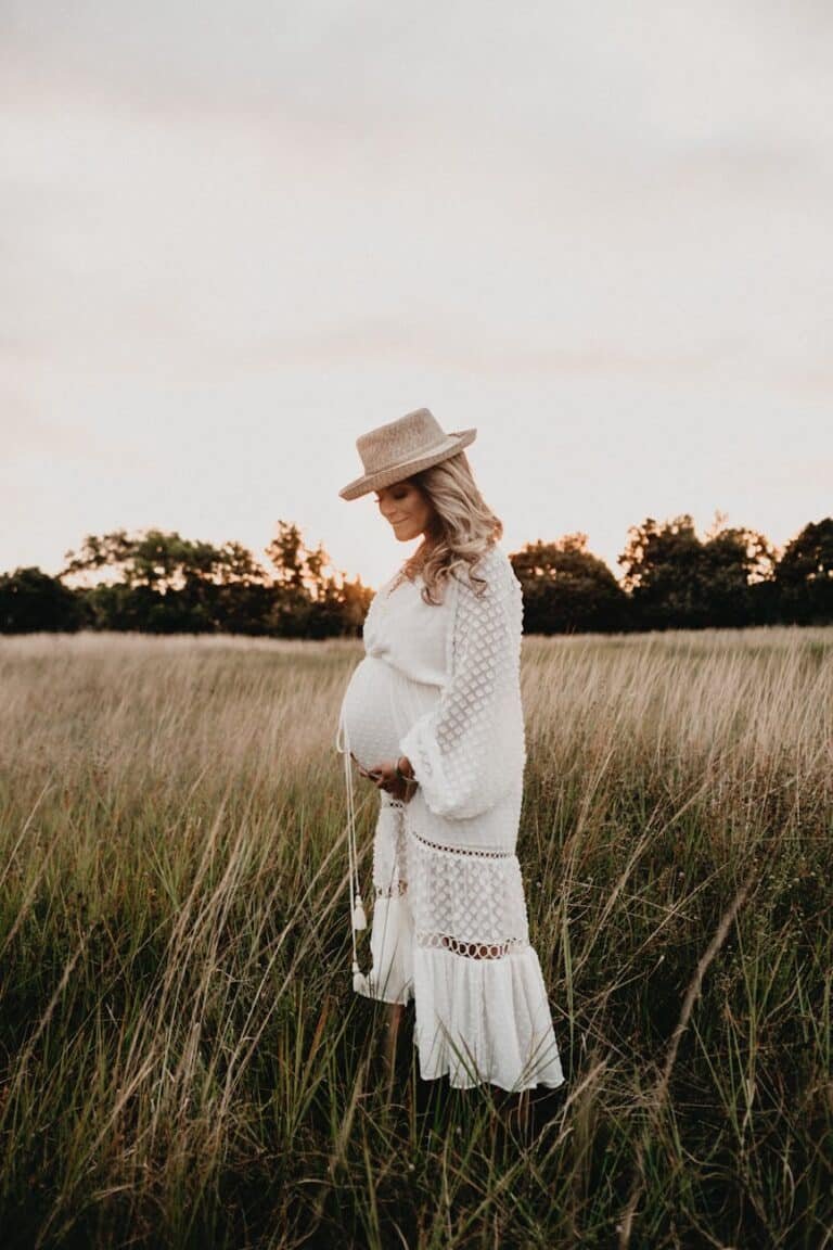 photo of pregnant woman standing on field