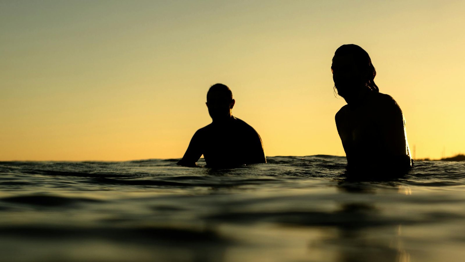 silhouette of two person in water