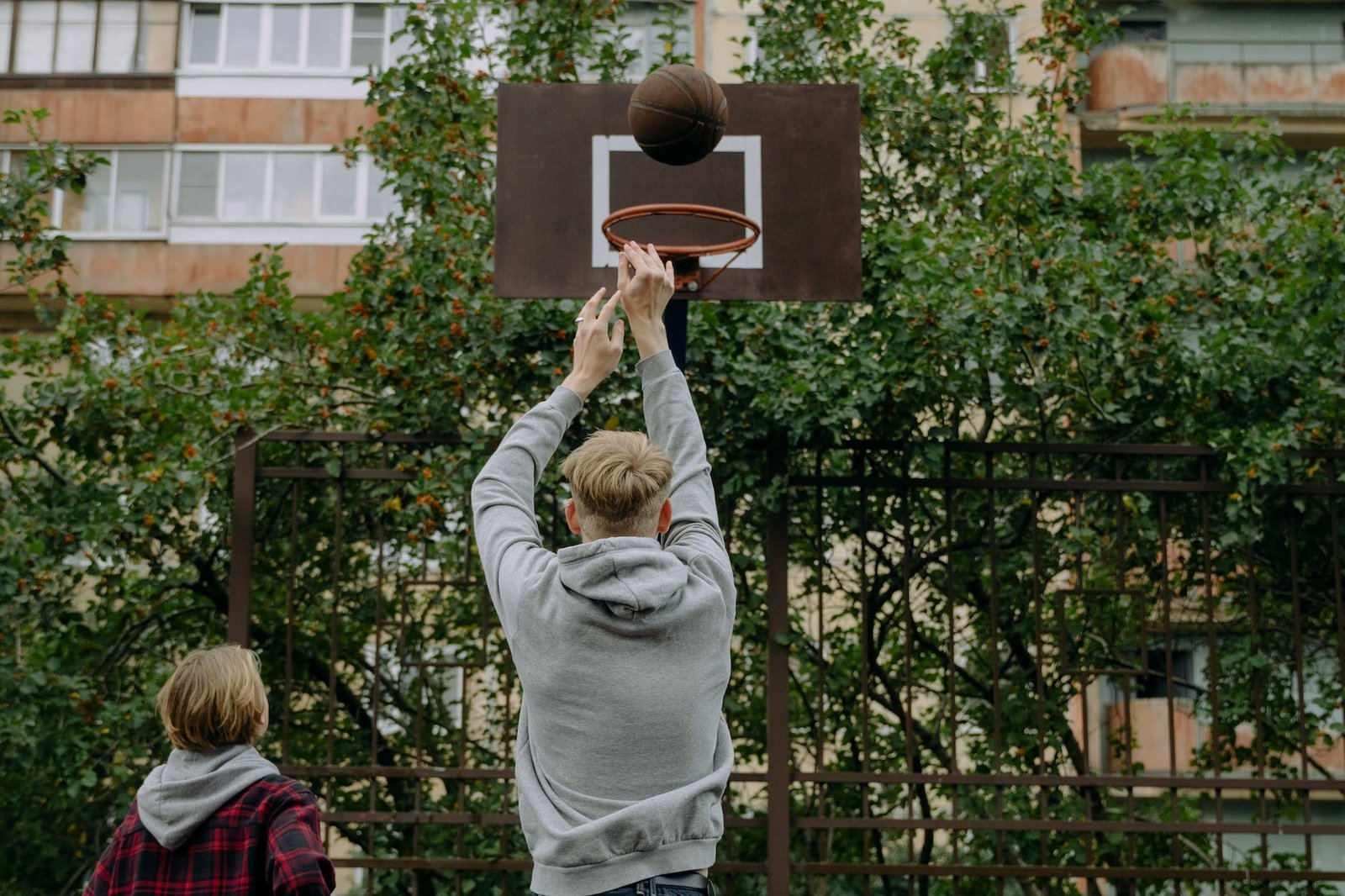 a man in gray hoodie shooting a ball