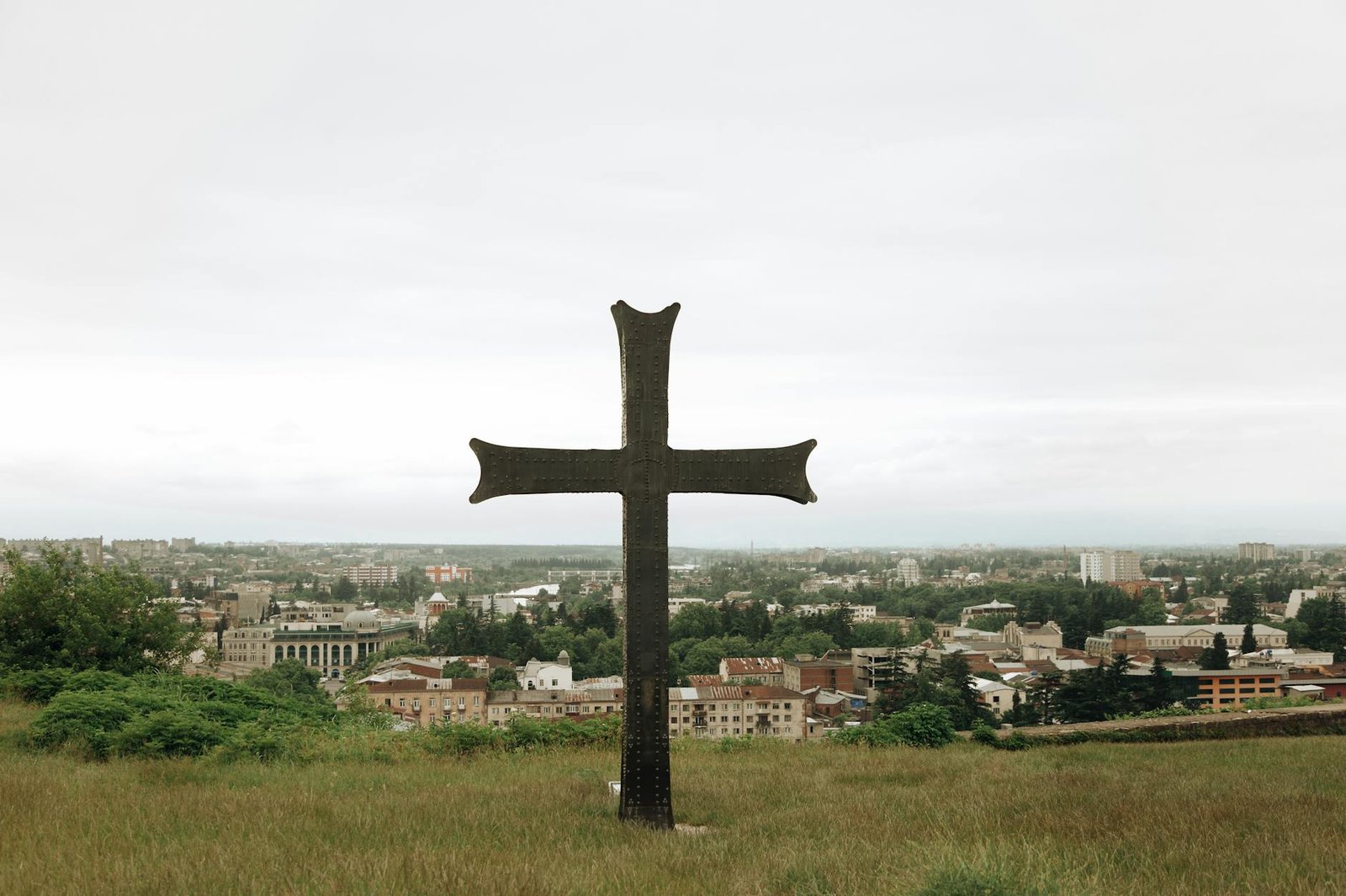 cross on hill over town