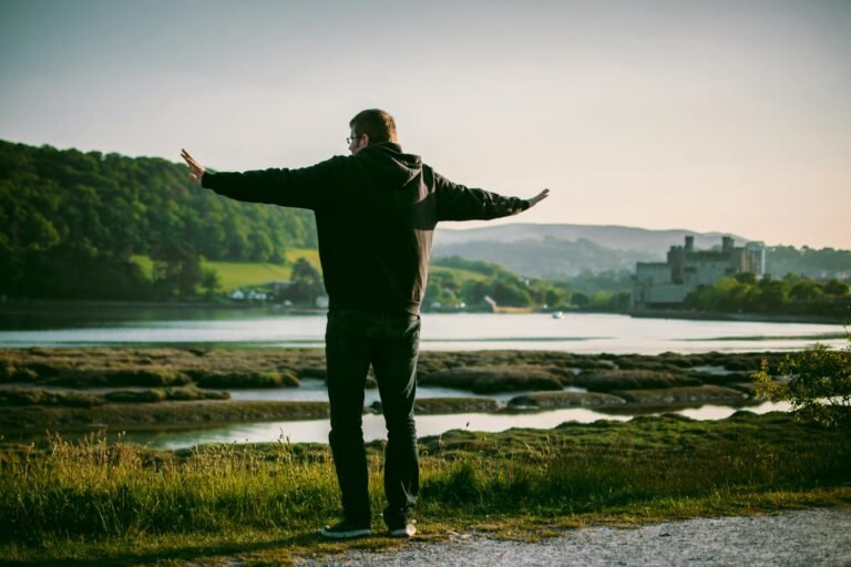 man wearing black jacket near on body of water