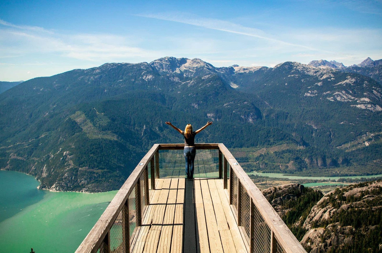 person in wooden balcony overlooking mountains