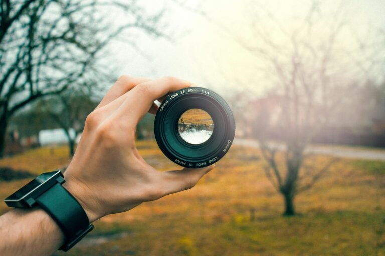 photography of person holding black camera lens