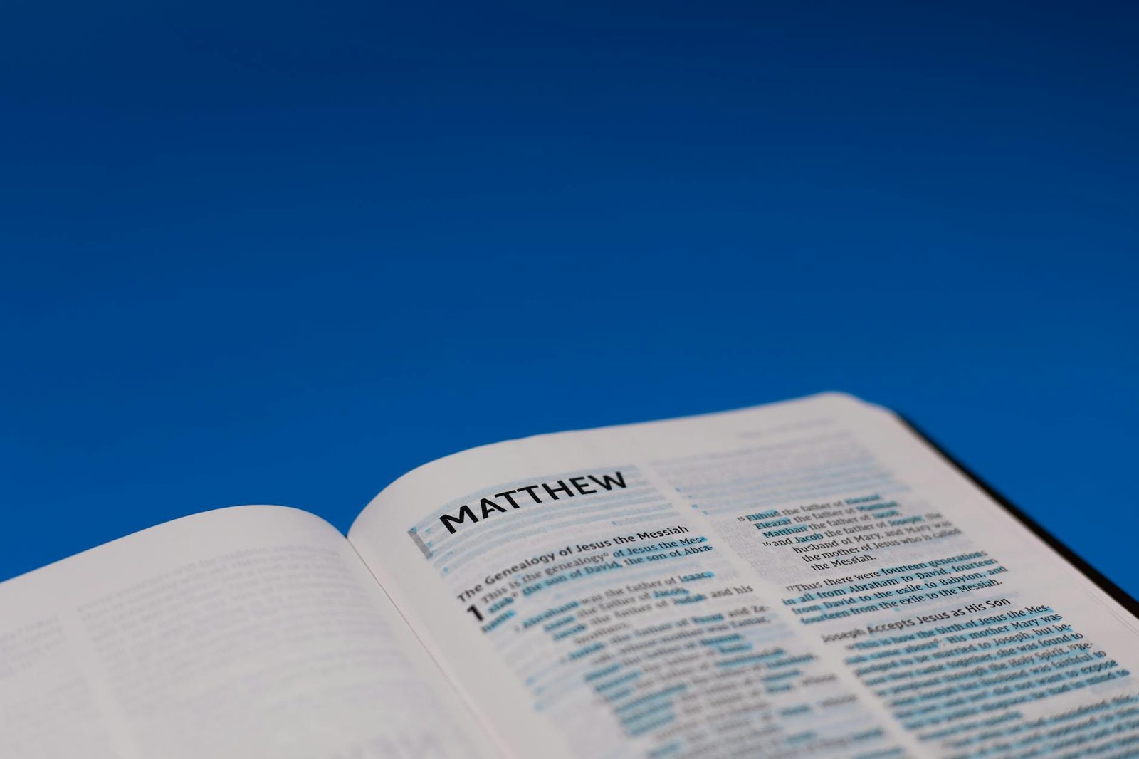 close up shot of an open bible on a blue surface