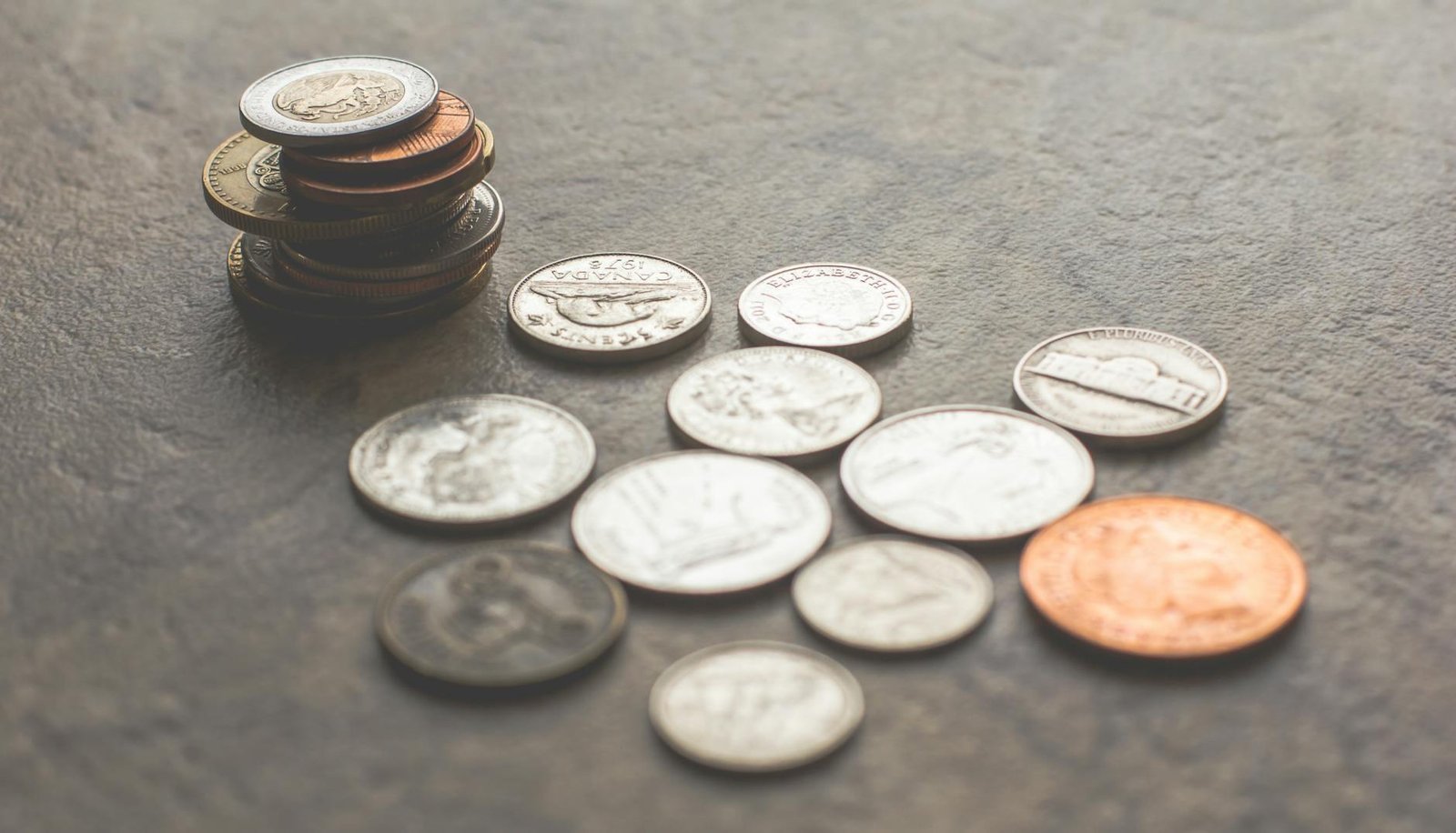 assorted silver and gold colored coins on gray surface