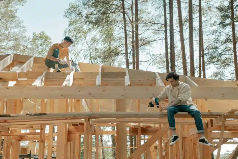 men working on wooden trusses of a house