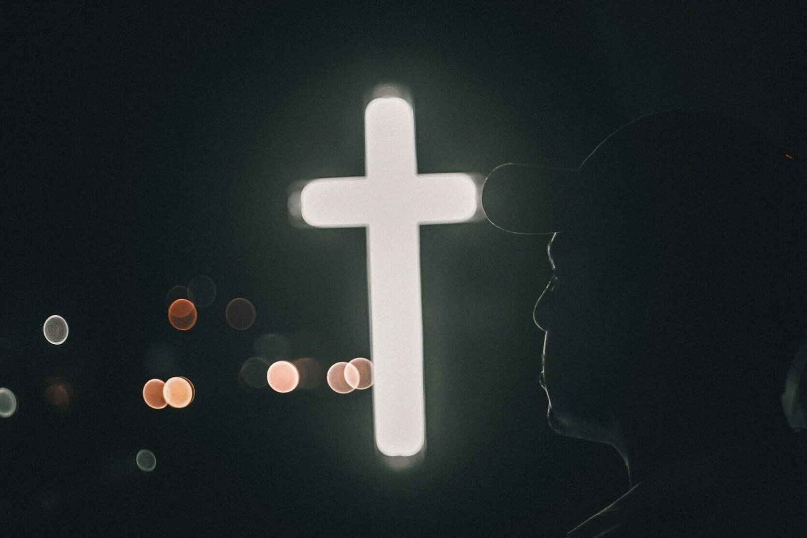 man by illuminated cross