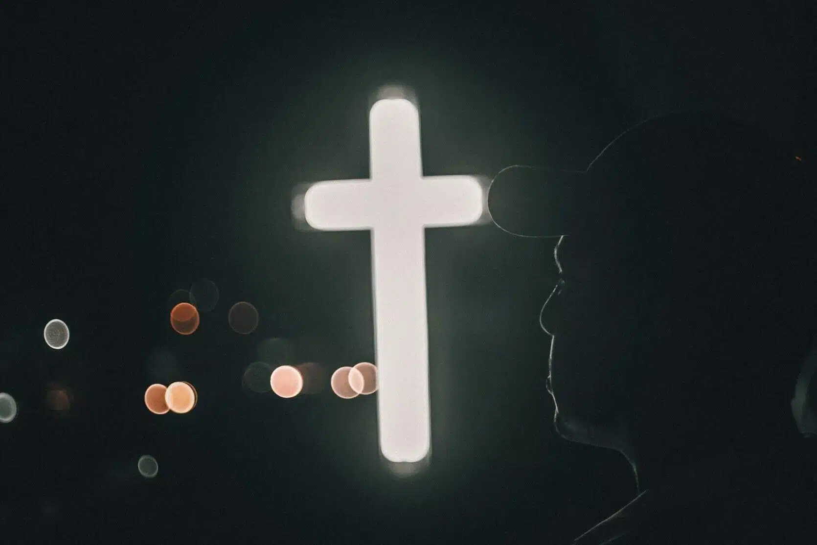man by illuminated cross